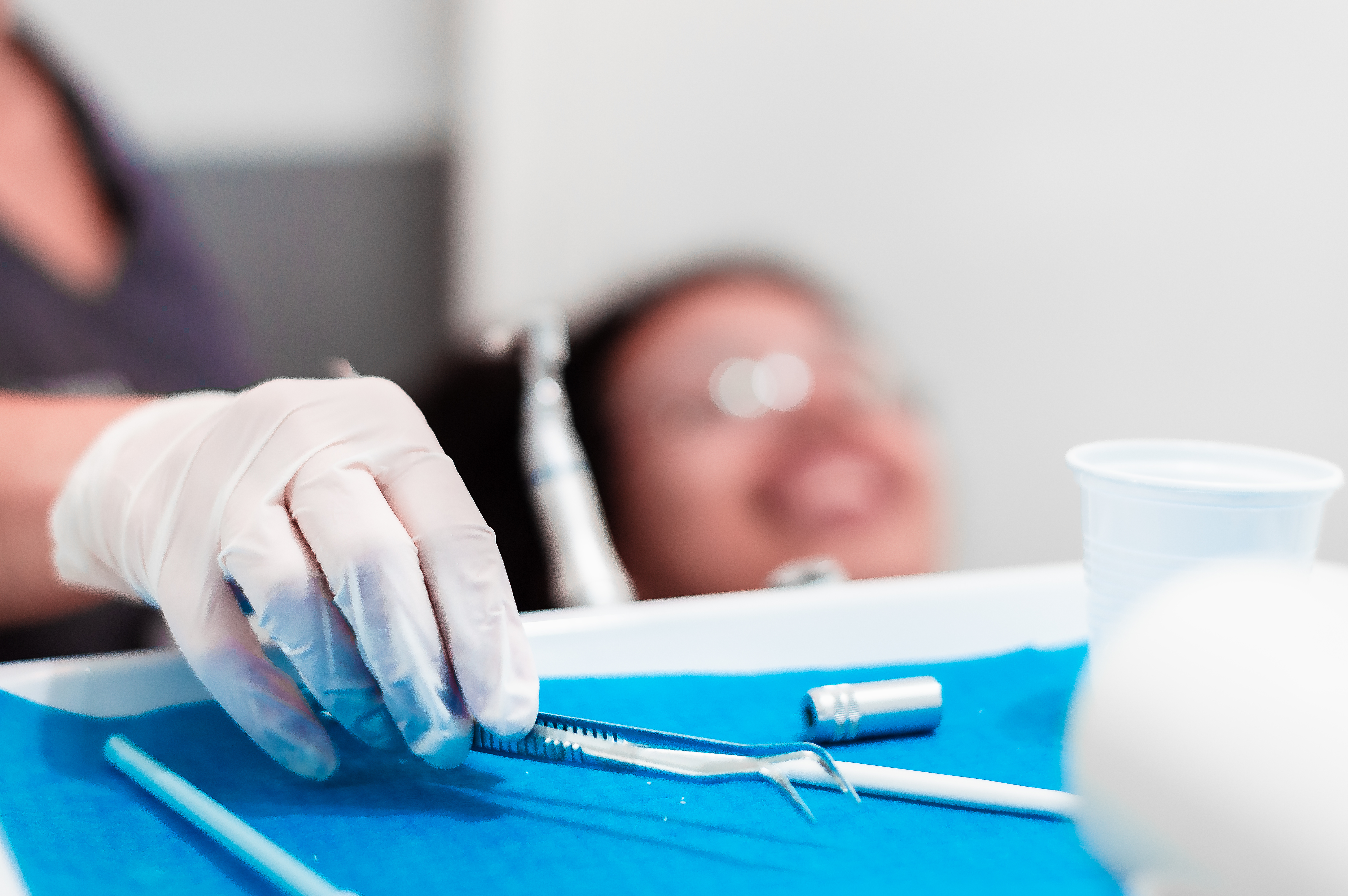 image of the hands of a professional dentist holding a dental cleaning instrument.